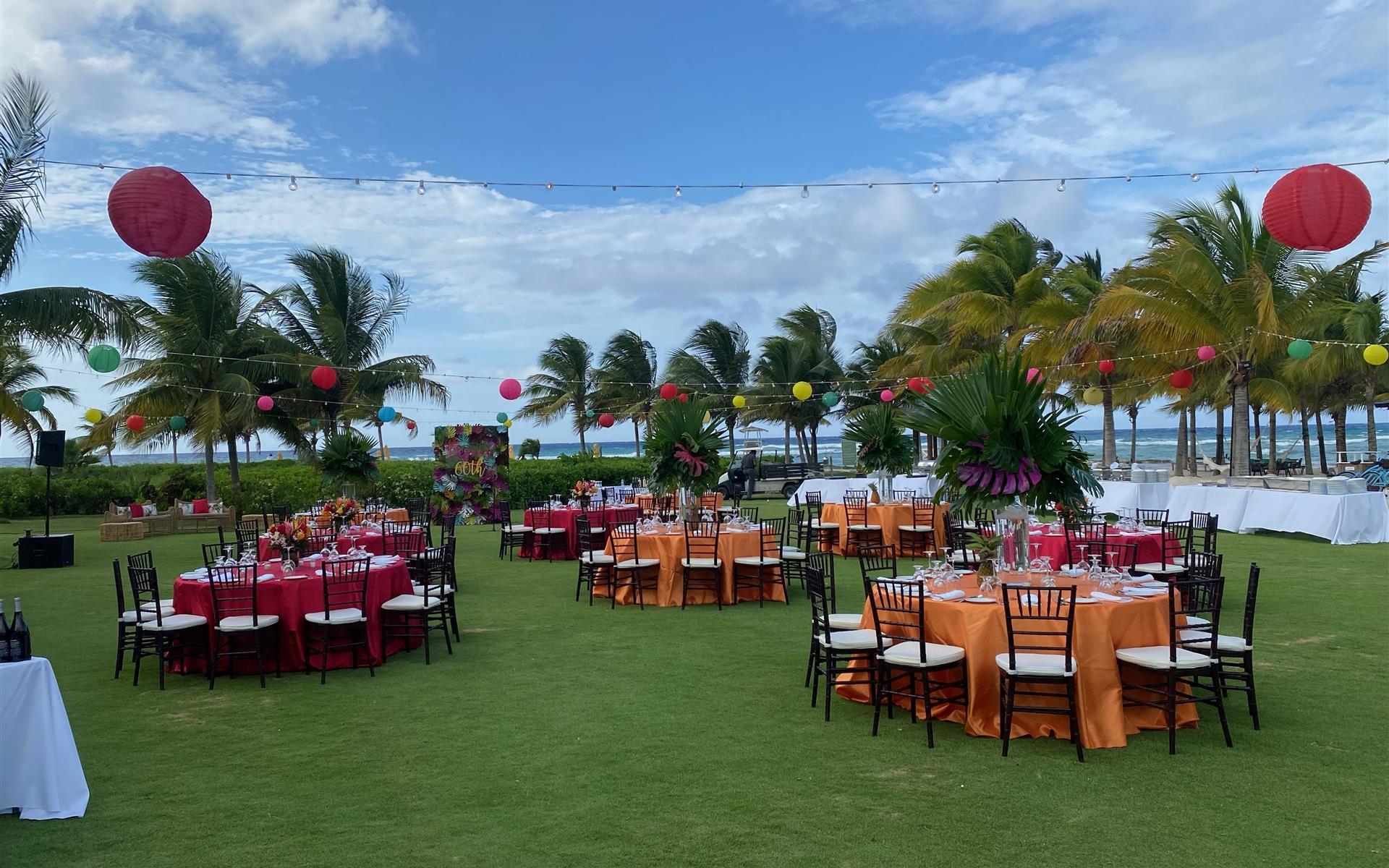 A lawn with tables and chairs with a view of the ocean