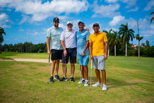 Four golfers smiling together