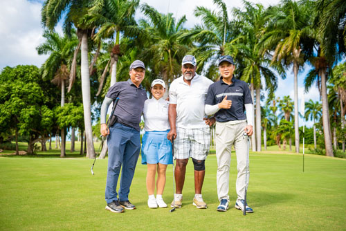 Golfers smiling together with palm trees in the background