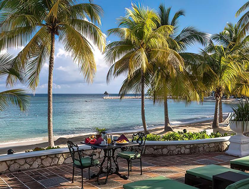 A table and chairs on a patio overlooking a body of water