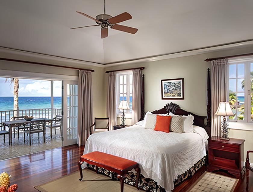 A bedroom with a large bed and a view of the ocean