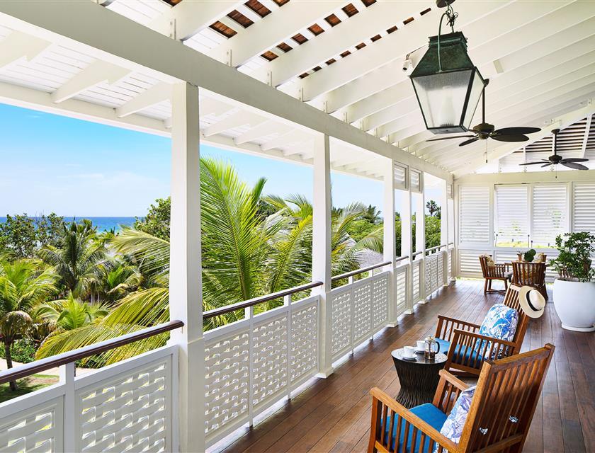 A porch with chairs and a ceiling fan