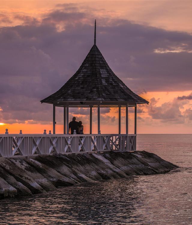 A man and woman standing on a pier overlooking water